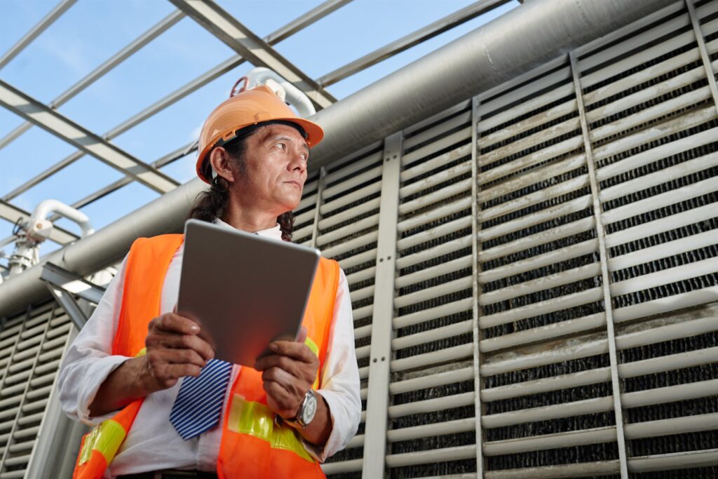 EM3 engineer with a tablet assessing an industrial utility system on site