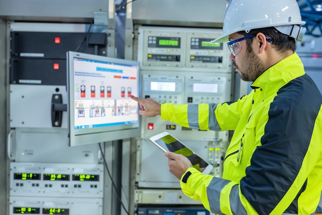 Engineer reviewing monitoring screens and instruments while investigating a complex control system