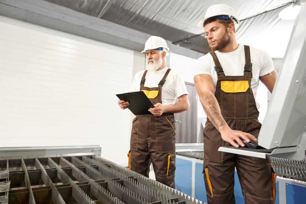 Two engineers in protective equipment working on an industrial plant floor