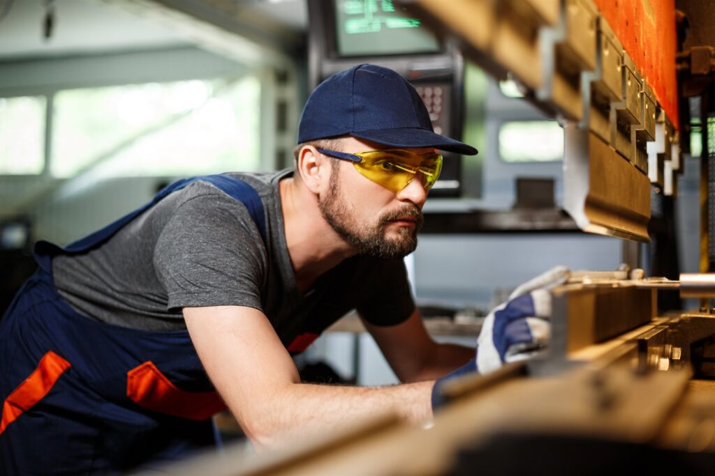 EM3 engineer beside industrial machinery on the factory floor