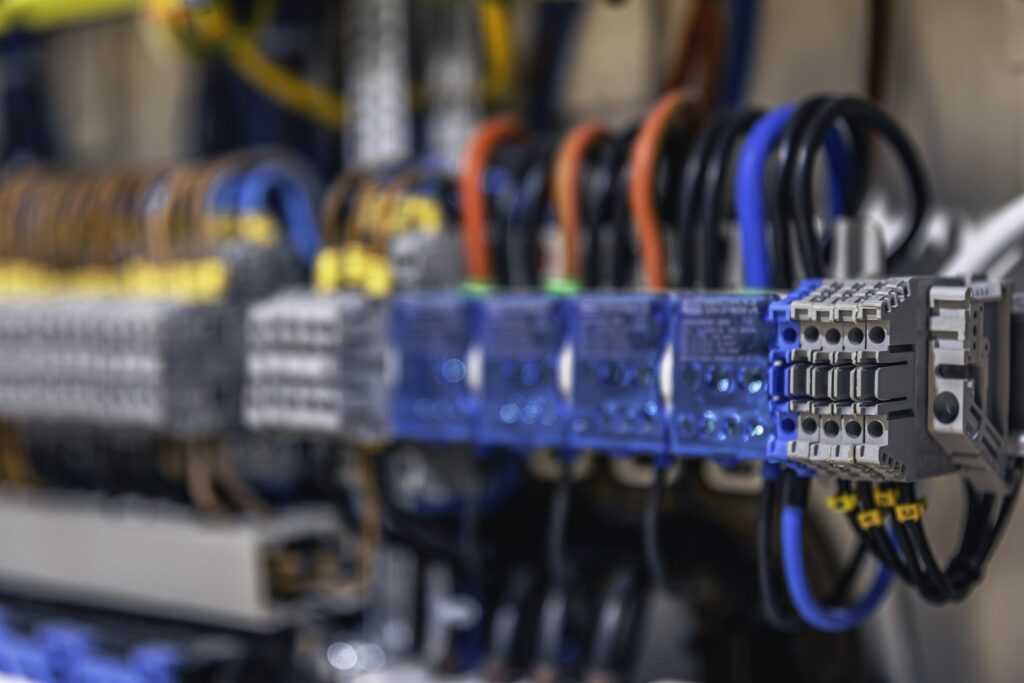 Close-up of a tangle of wiring, fuses and contactors in an industrial metering panel