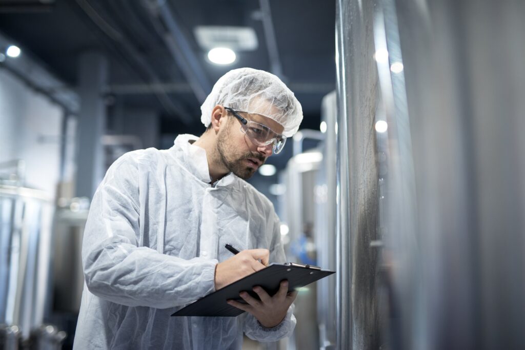 EM3 engineer in protective uniform monitoring an industrial process on site
