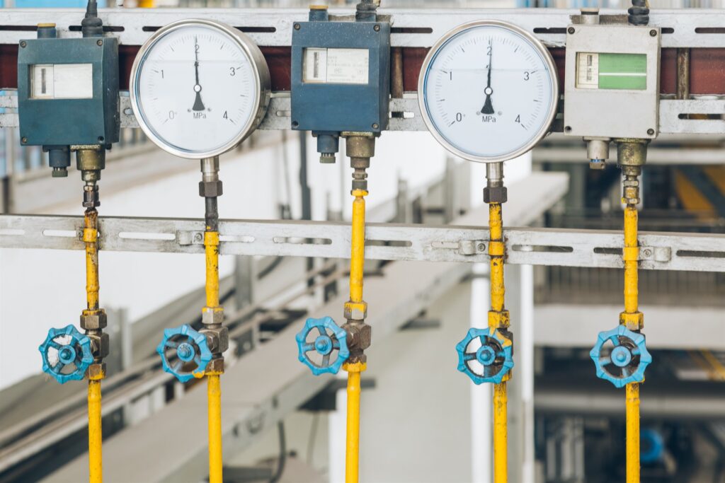 Industrial system pipework, gauges and valves on a plant floor