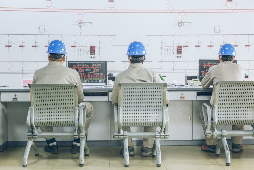 Operators monitoring process data at a control-room mimic board