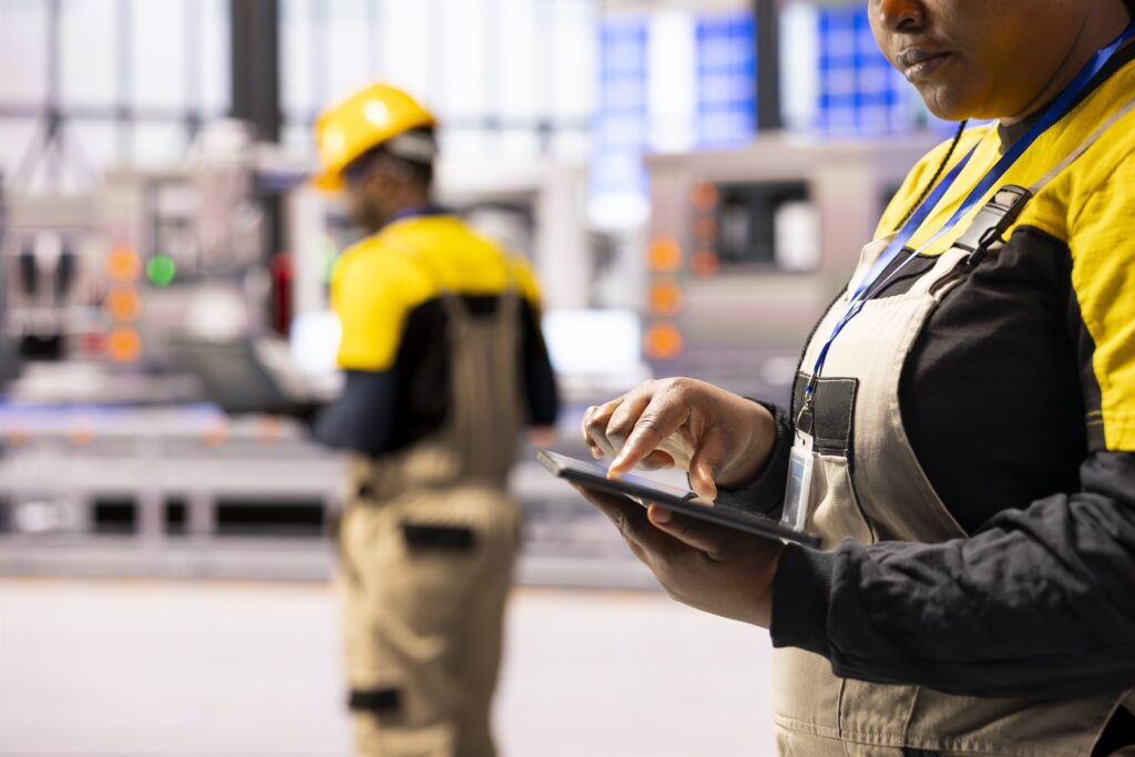 Engineers analysing technical project data on a tablet on a plant floor