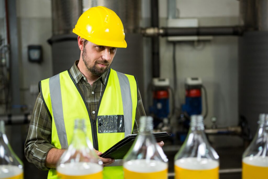 Engineer reviewing project savings data on a tablet in an industrial plant