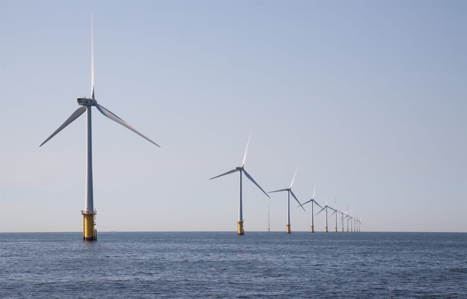 An offshore wind farm, a line of turbines reaching to the horizon, representing the scale of the SHV Energy group behind EM3